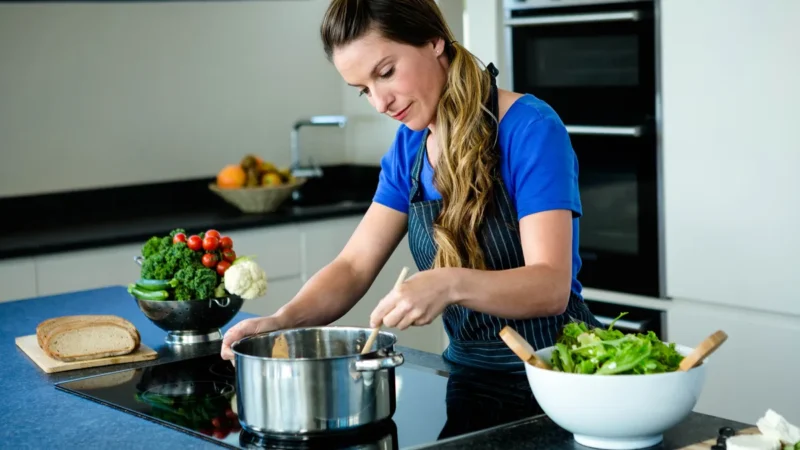 Frau bereitet in der Küche frisches Gemüse und Salat zu