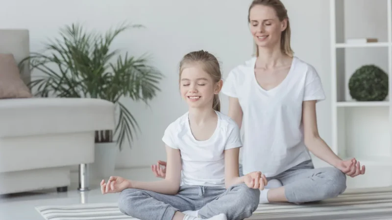 Mutter und Tochter turnen gemeinsam auf Gymnastikmatten